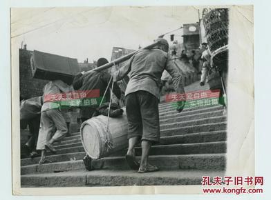 1944年中国首都四川重庆扬子江畔码头，在山路台阶之上抬货物的市民老照片，22.8X17.8厘米