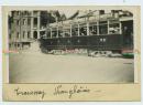 民国时期上海老洋房街道，一辆载满乘客的有轨公共电车老照片