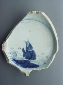 清代青花瓷碗残片，碗心绘一条鲤鱼跃出水面，底部写豆腐干款。尺寸：长约13厘米，宽约11厘米