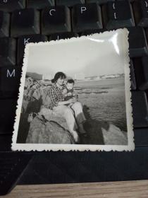 老照片 母亲抱着孩子坐在石头上