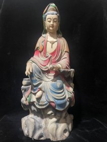 清代老檀木雕彩绘【读经卷观音】 高59宽38厚19cm， 观音面带微笑，神情祥和自然，右手捧经卷，左手搭滕盖，腿自然下垂，整体雕刻细致精湛，曲线婉转流畅，皮克老辣，自然磨损，历史沧桑感十足