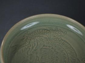 旧藏 龙泉窑 祥龙纹 卷唇 文房笔洗 尺寸：直径18.5cm，高5cm 简介：龙泉窑是中国历史上的一个名窑，宋代六大窑系。汉族传统制瓷工艺的珍品。因其主要产区在浙江省龙泉市而得名。它开创于三国两晋，结束于清代，生产瓷器的历史长达1600多年，是中国制瓷历史上最长的一个瓷窑系，它的产品畅销于亚洲、非洲、欧洲的许多国家和地区，影响十分深远。龙泉窑以烧制青瓷而闻名，在北宋早期以前的产品风格受越窑、