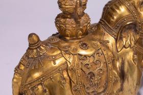 铜鎏金象 描述：此象以铜精铸，通体鎏金，金水饱满肥厚，宝光华美。大象作立姿前行状，长鼻向上扬起内卷，四足健壮如柱，神态安详温和，一幅悠然自得的模样，造型典雅，铸工精良。 尺寸：长21 宽15 高36cm 重18500g