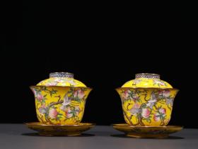 清代 铜胎黄釉画珐琅寿桃仙鹤纹茶盖碗一对。
