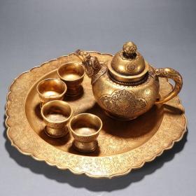 旧藏 铜鎏金三宝花卉纹茶具一套。 规格：壶高16㎝宽22㎝，杯高5㎝口径6㎝总重5斤