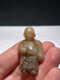 宋 和田玉籽料 白玉黑沁 文官 人物 挂件 把件 摆件 长2.6 宽1.6 高4.8厘米 重24克 和田白玉，局部黑褐沁色，间有大片“牛毛纹”，古朴优雅色泽沉蕴温润，古朴沉蕴，立体圆雕一站立文官。乐官头戴幞帽，脸庞圆润，弯眉大眼，眼皮下垂，蒜头鼻凸出，嘴角上扬。身体矮胖健壮，穿着宽袖束腰长袍，衣褶自然优雅，双脚穿靴。整器推磨精细，造型古朴，刀法粗犷，可谓宋代玉雕人物之精品。