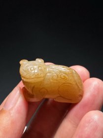 明 和田玉籽料 白玉 沁色 兽衔灵芝 挂件 把件 长3.6 宽1.6 高2.2厘米 重20.9克 瑞兽籽料白玉质地，玉质细腻温润，局部留皮，黄褐沁色，玉质包浆老旧，古意盎然。整体圆雕作一侧首瑞兽，瑞兽宽口圆眼，口衔灵芝，身姿蜷伏，长尾侧摆甩于背上。整体造型精致美观、独特传神，寓意吉祥如意，具有明代玉雕的拙朴特征。