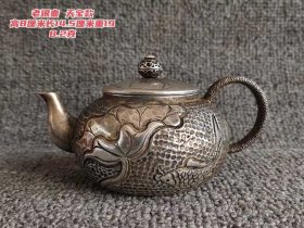 15_老银壶，天宝款。高8厘米，长14.5厘米，重198.2克 。壶身之上，莲花舒展，鱼儿悠游，细腻的錾刻工艺让图案栩栩如生，仿佛能感受到荷塘的静谧。壶钮精巧别致，壶把线条流畅，整体散发着古朴典雅的韵味，既适合烹茶品茗，又是一件极具收藏价值的古典美器。1_ykY2Kr