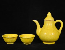 明成化黄釉雕刻龙纹茶具一套，壶15×14.5厘米，杯3.8×7.5厘米