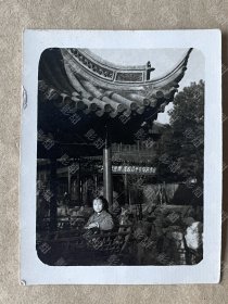 老照片，美女， 可能是上海豫园，远处有毛主席