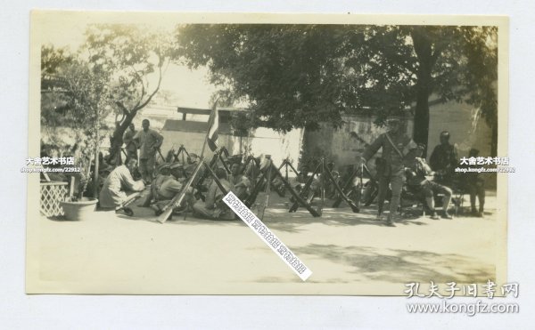 1928年在北京街头行军间隙休息的国民革命军北伐军部队老照片，注意左臂都带有袖章以示区分敌我。大背景是蒋介石统率冯玉祥、阎锡山、李宗仁各路军北上，驱赶北京安国军政府陆海军大元帅张作霖。11.1X6.6厘米，泛银