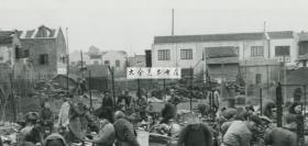 1945年1月上海棚户贫民区大火火灾后，百姓整理被烧毁的家园老照片。22.8X18.1厘米