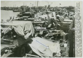1949年美联社新闻传真照片一张，国民党军队部队从广州大撤离，军用卡车和其他车辆在珠江码头登上一艘坦克登陆舰，准备前往海南岛。车辆装载完毕后，部队及其家属纷纷也登上战舰撤退。20.4X14.3厘米