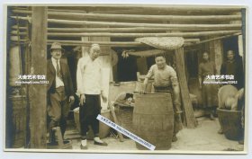 1920年代美国杜邦公司洋人考察江苏苏州的染坊，和染坊老板伙计合影老照片一张，右侧伙计身前就是盛放杜邦公司染料的木桶，上部的竹木架子是晾晒染印好的成品布用的。整组照片和当时美国杜邦公司向中国传统染坊推广“阴丹士林”靛蓝染料的商业调查和活动有关。13.5X8.3厘米。泛银
