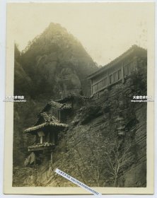 民国朝鲜金刚山普德庵老照片一张，10.4X7.9 厘米。普德庵本殿是倚着普德窟前面的岩石，在高20多米的悬崖峭壁上建造的用一根铜柱支撑的单间房。这个建筑的房顶为三层。