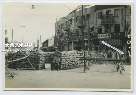 1937年淞沪事变八一三抗战时期，守卫在上海租界入口处的外国士兵老照片，其目的是保卫租界外国人安全，防止中日交战双方的进入。荣昌钟表号，新新洗染厂，男女理发新式电发，林荣记服装，孙亿鑫钟表行。8.4X5.8厘米，泛银