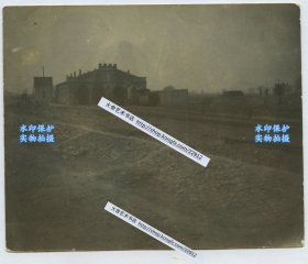 清代1900年北宁铁路（时为关内外铁路）北京丰台车房的机车库老照片。该车库在1900被义和团捣毁，仅留下废墟影像，这张是罕见被毁前的影像，可见屋顶城垛式装饰、横匾、横匾下方长条采光窗及下面四道券门。有火车机车停留在附近。12X9.8厘米。