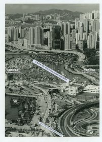 1987年4月香港海底隧道、香港皇家游艇会及铜锣湾东区走廊全景照片一张，自西向东拍摄，画面右侧是告士打道，东区走廊双向车道在此分叉，东区走廊的北面是港湾码头，停满了各种小船，不远处就是香港游艇协会，以及大名鼎鼎的红磡海底隧道入口。24.1X17.1厘米