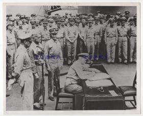 1945年9月2号，美国海军上将尼米兹在密苏里号战列舰上，签署日本投降的文件。