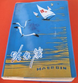 【哈尔滨日记本】一九七七年五月唐山地区印刷厂革命委员会奖品。1976年哈尔滨印刷制本厂制作，塑皮精装。胶版纸，100页（正反面200页），36开，尺寸（长×宽×厚）：17.9厘米×12.9厘米×1.0厘米，全新未使用，封面印哈尔滨松花江风景名胜图案。内页附上世纪七十年代初北京及哈尔滨历史名胜彩色图片6幅：“东方红”“天安门”“北海公园”“颐和公园十七孔桥”“黑龙江省展览馆”“哈尔滨人民防洪纪念塔”