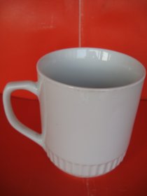 【一帆风顺：二十世纪九十年代中国景德镇烧制大号茶杯】圆柱形，有手柄。口内直径7.2厘米，口径11.0厘米，壁厚0.3厘米，通高15.0厘米，通长（含杯柄）14.5厘米，636.0克。杯体手绘帆船图案，题字：”一帆风顺”。杯底有款：“中国景德镇”。杯内底有深色釉斑，全新未曾使用，完整无缺，完好无损。