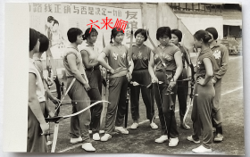 老照片：时期—体育运动—美女射箭队——山东、内蒙古、北京体育学院等 。背景有“毛主席语录：思想上政治上的路线正确与否是决定一切的”。——校简史：筹建于1952年，原名中央体育学院，1956年更名为北京体育学院，1993年更名为北京体育大学。
