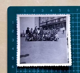 早期女青年在辽宁“本溪文化宫”合影照片，背后有标语“创造新成绩，争取上北京”，品相如图，长6厘米，宽5.8厘米