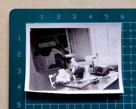 六七十年代青年干部在办公室里看毛选照片，背后墙上贴有大幅宣传画“将革命进行到底”，品相如图，长5.8厘米，宽4.3厘米