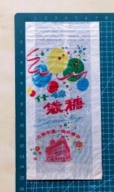 早期上海市第一食品商店“什锦袋糖”纸质糖果袋，图案为气球和上海市第一食品商店大楼，品相如图，长15.2厘米，宽7.2厘米