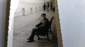 早期戴眼镜的男子在连椅上休息黑白照片。