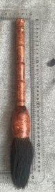 确定为木质的花梨木老毛笔，笔杆长27.5厘米，最大直径4.5厘米，笔毛长12.5厘米，水湿后味重，笔头已脱落，如图。