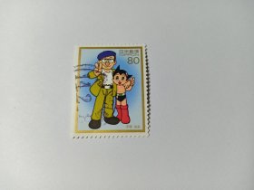 日本邮票 80円 1997年战后50年艺人 漫画家手冢治虫和卡通人物 铁臂阿童木 手冢治虫1928-1989日本漫画家、动画制作人、医学博士。1947年《新宝岛》奠定了日本漫画的叙述方式，创立了日本漫画意识形态，极大的扩张了新漫画的表现力。1952《铁臂阿童木》轰动日本，1953年《缎带骑士》则是公认的世界第一部少女漫画。1988年作为中日交流大使出席第一届上海国际卡通节与严定宪和万籁鸣会面