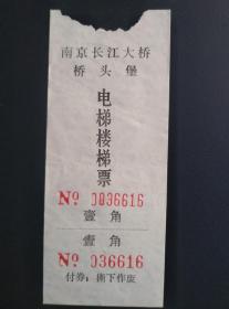 南京长江大桥桥头堡 电梯楼梯票 票价1角 南京长江大桥于1969年建成通车。大桥的正桥与引桥接壤处采用复堡形式的桥头建筑过渡,由大堡和小堡组成。大堡由两座塔楼和大厅组成。每座塔楼高约70米，底层与大厅相联，设有楼电梯通向铁路、公路桥和瞭望平台。桥头堡顶部是三面飘扬的红旗。