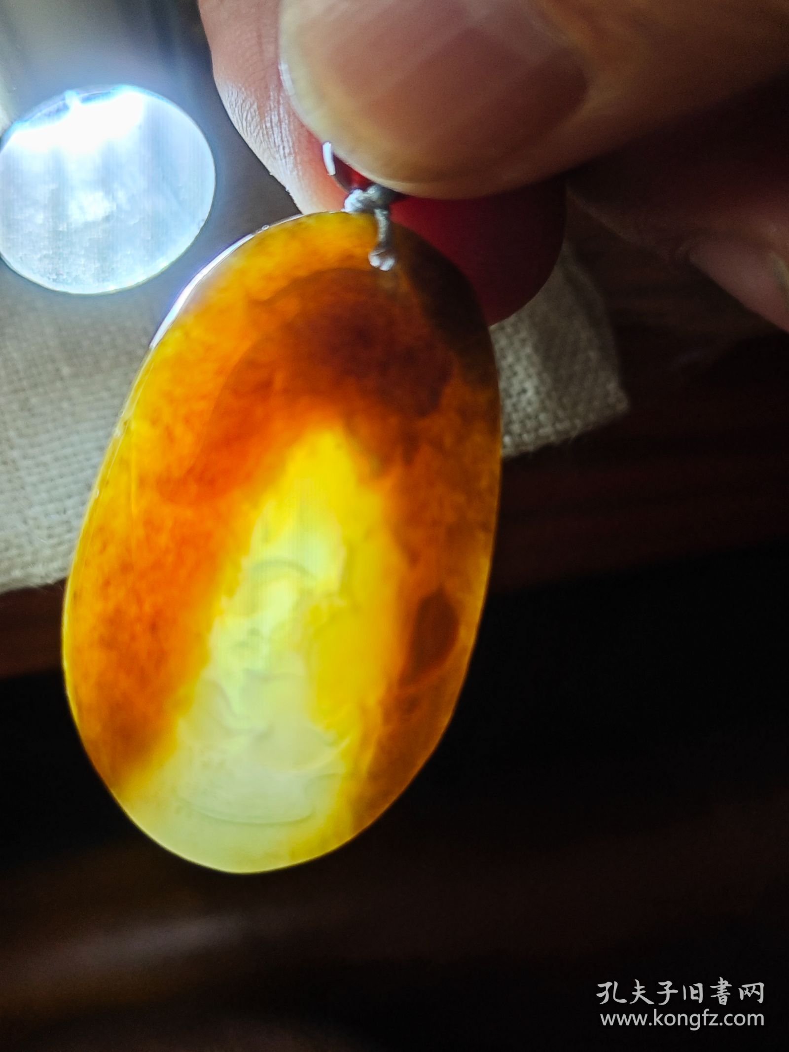 包邮 老料【新疆且末糖青玉老料 糖包肉 小鱼戏莲 椭圆牌】长3.7宽2.35厚0.55重10g，在手近十五年。玉质一眼老货，透光打灯可见下三面糖包肉，只在底部一小块可见肉色。包浆老，手感舒适。雕工一般，但比较写意。加了串绳，性价比高。关键是很润。