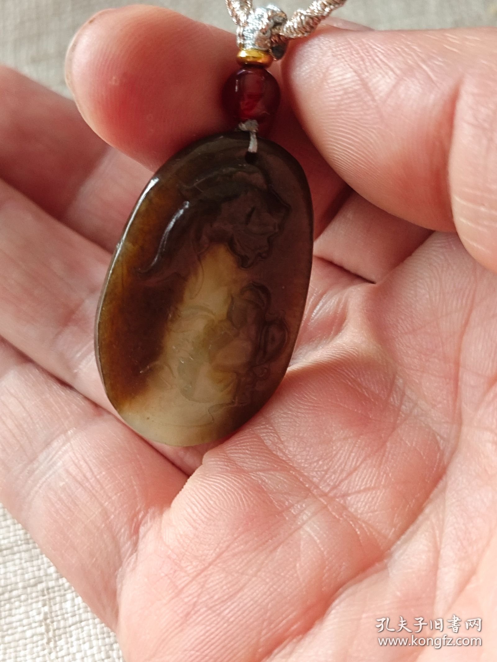 包邮 老料【新疆且末糖青玉老料 糖包肉 小鱼戏莲 椭圆牌】长3.7宽2.35厚0.55重10g，在手近十五年。玉质一眼老货，透光打灯可见下三面糖包肉，只在底部一小块可见肉色。包浆老，手感舒适。雕工一般，但比较写意。加了串绳，性价比高。关键是很润。