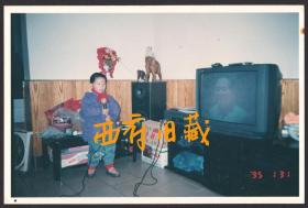 1995年，唱红歌的小男孩儿，电视里播放着毛主席的画面