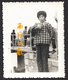 红色年代老照片，穿着格子衫，把毛主席语录红宝书举在胸前的女学生