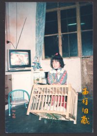 1993年，电视里播放着动画片，桌子上放着动物玩具，双手提着兔笼子的可爱小姑娘
