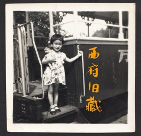 怀抱着玩具布娃娃的蘑菇头小姑娘，两个的发型很相似
