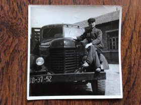 老照片，一位军人座在老解放汽车车头上的留影