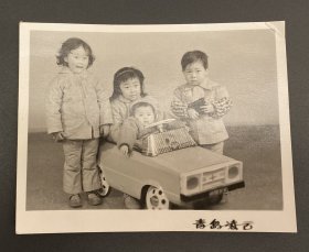 老照片：幼儿4人合影照（青岛凌云，纸厚，汽车望远镜道具）/尺寸：10.6CM*8.3CM