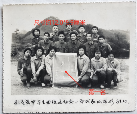 老照片：安徽省祁门县第一中学，1981年10月，参加祁门县中学生田径运动会代表合影，“第一名”锦旗。——祁门一中校简史：1939年夏由毕业于国立东南大学的胡术五先生，在大学同学程以仁先生和毕业于清华的戴振辉先生的同心协助下创办，初名祁阊初级中学。1949年易名祁门县初级中学。1958年改称祁门中学。1969年更名祁门县五七中学。1972年分设南、北两部教学。1976年分设为祁门一中和祁门二中。