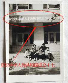 老照片：美女，手拿红宝书，学习毛主席语录，1966年国庆节，背景建筑有“庆祝中华人民共和国成立十七周年”横幅。【陌上花开系列】