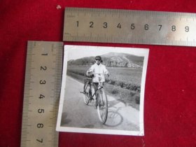 云南江川老照片系列，七八十年代，女人推着永久自行车照片（背景：七星塔），