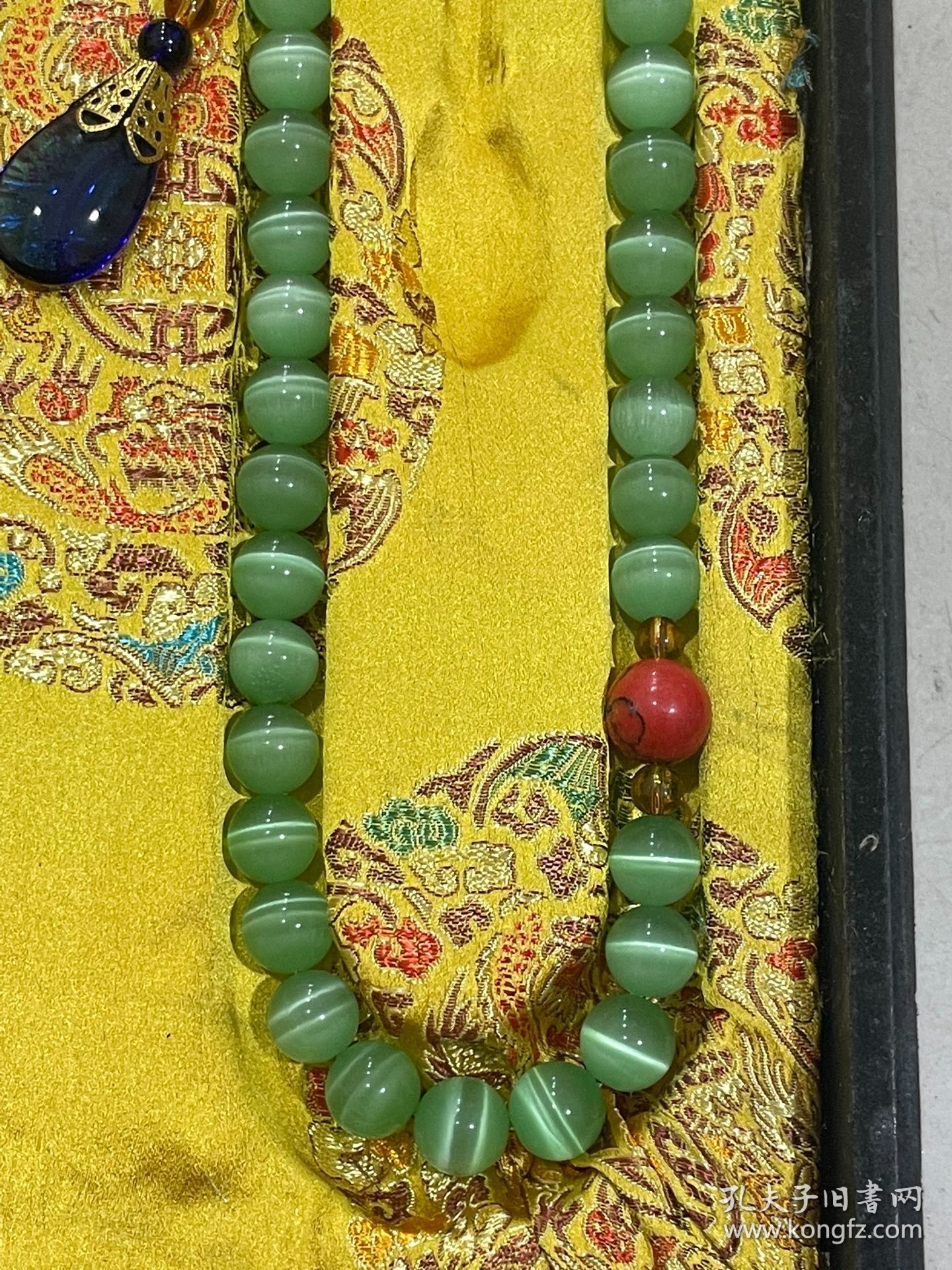 宫廷御用龙纹漆器盒内放猫眼石朝珠 清代朝服上佩带的珠串。朝珠是清朝礼服的一种佩挂物，挂在颈项垂於胸前。朝珠共108颗，每27颗间穿入一粒大珠，大珠共四颗，称分珠，根据官品大小和地位高低﹐用珠和绦色都有区别。 盒子尺寸:长45.5cm，宽30.7cm，高5.5cm