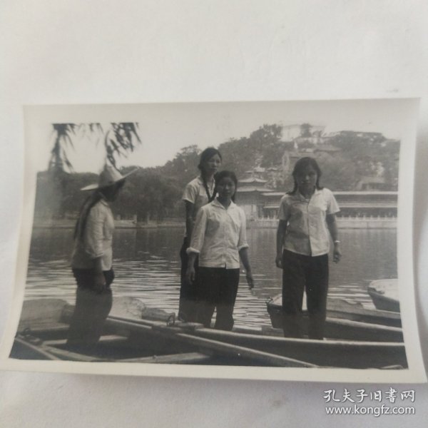 几位美女站在湖中的小船上合影留念照片
