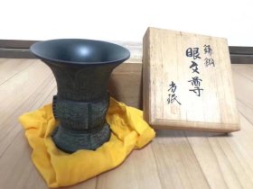 金工艺术家小林尚珉仿中国西周器物：眼文尊 高10.5cm，上部口径9cm，底部直径6.2cm。付原木箱（盖子小裂缝）。说明：小林尚珉（1912-1994） 工芸家 金工 ,得意：彫金 .昭和１６年日展連続入選。奉祝文展出品作推奨。北斗賞受賞。菊花賞受賞。京都府自治功労賞受賞。京都府文化功労賞受賞。平成6年（1994年）去世。享年82歳。日展（日本美术展览会）会員。日展審査員。京都府美術展審査員。