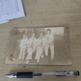 明信片式老照片：4名白衣帅哥（兄弟）中间两带眼镜白衬衫领带，右也白衣中山装手（著名指挥官？）左边白衣小男孩/精美老家具/背景后大树林