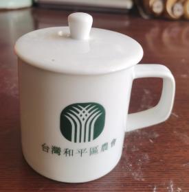 台湾和平区农会：茗真饮顺小盖茶杯，高8cm，杯口直径7cm，杯口处有一倒水的小口，杯瓷精细，造型别致，精美，有一台湾和平区农会的会标！精品！！