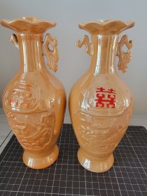 上个世纪70-80年代， 黄釉 电光瓷 开窗 （双喜字） 浮雕 《祥云龙纹》酒瓶子2件，各缺一只凤耳，高约22.8厘米。